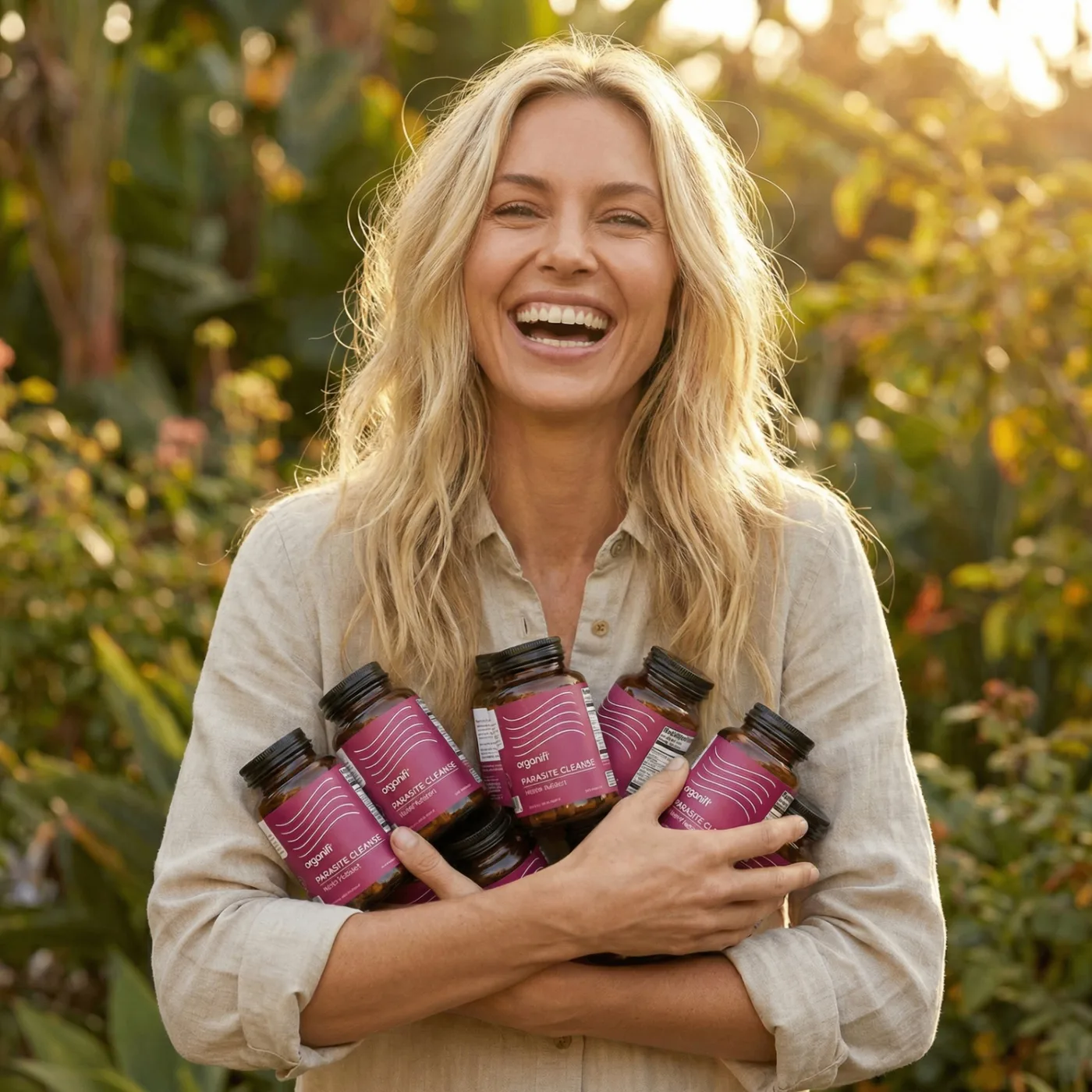 Smiling woman holding Organifi Parasite Cleanse bottles